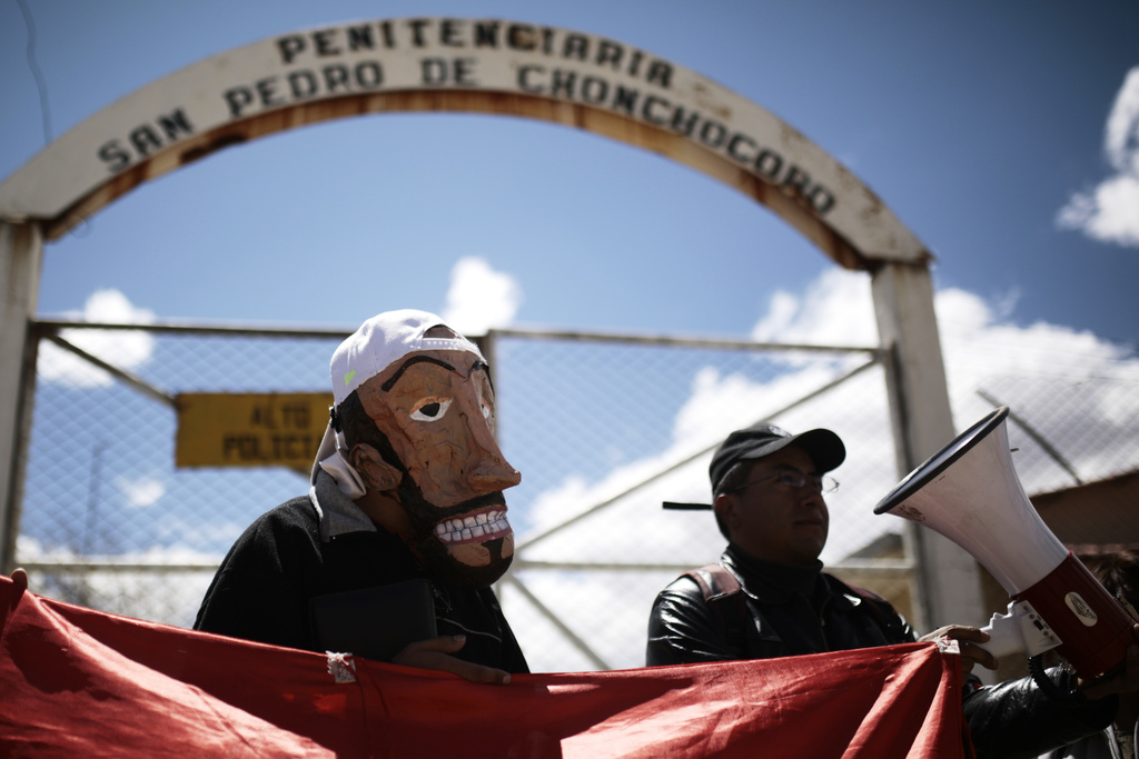 A supporter of opposition leader Luis Fernando Camacho wears a mask in his likeness outside the jail as he awaits the leader's release from jail who was allowed house arrest after almost three years in pretrial detention for his involvement in violent unrest that led to the 2019 ouster of then-President Evo Morales, in La Paz, Bolivia, Friday, Aug. 29, 2025. (AP Photo/Gaston Brito)