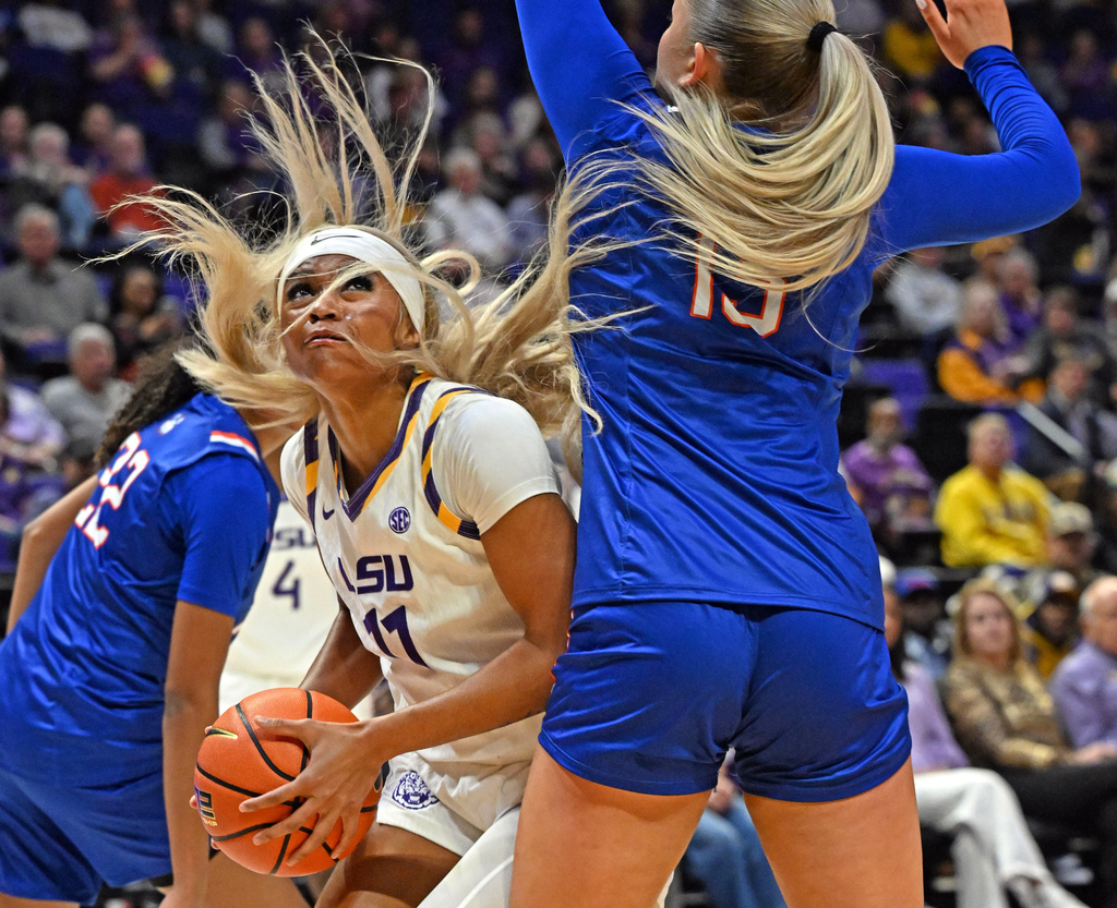 LSU guard ZaKiyah Johnson (11) moves past Houston Christian guard Tove Caesar (13) under the basket, Tuesday, Nov. 4, 2025, in Baton Rouge, La. (Hilary Scheinuk/The Advocate via AP)