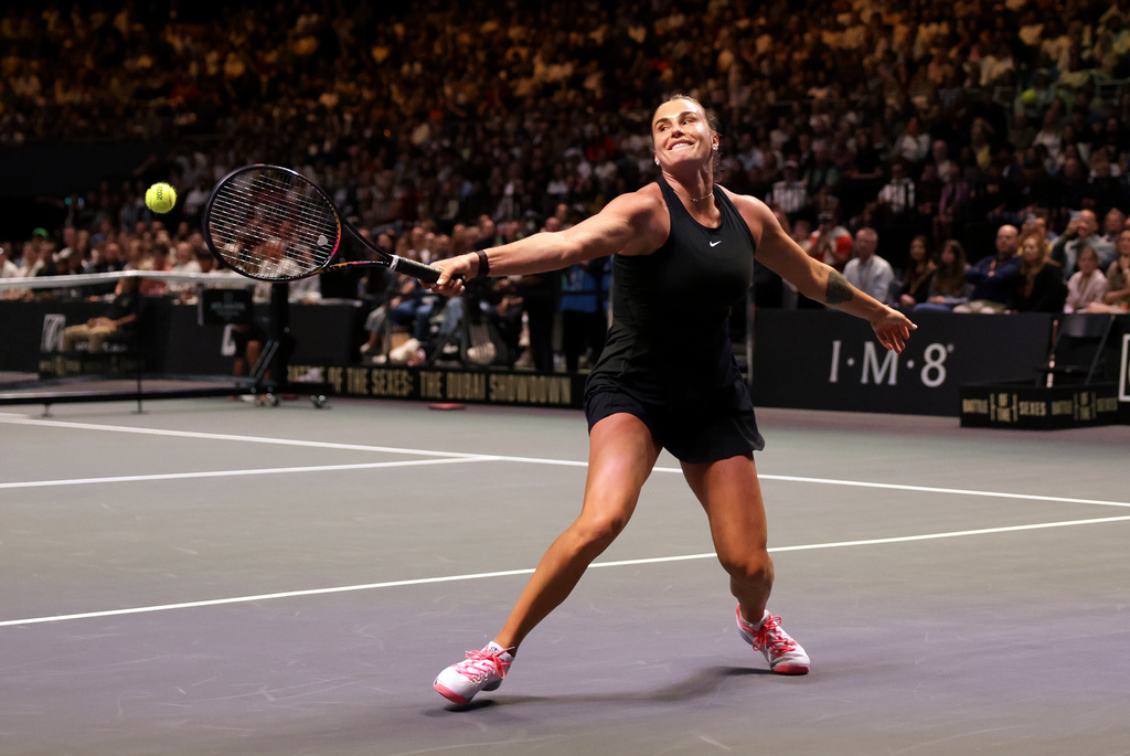 Aryna Sabalenka returns the ball to Nick Kyrgios during their Battle of the Sexes match in Dubai, United Arab Emirates, Sunday Dec. 28, 2025. (Christopher Pike/Pool Photo via AP)