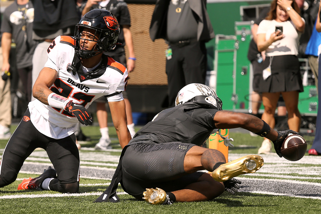 Oregon wide receiver Dakorien Moore (1) scores a touchdown while defended by Oregon State defensive back Jalil Tucker (22) during the first half of an NCAA college football game, Saturday, Sept. 20, 2025, in Eugene, Ore. (AP Photo/Lydia Ely)