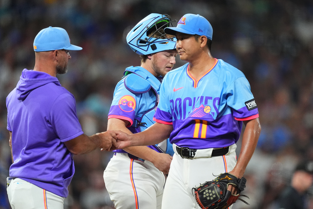 Colorado Rockies manager Warren Schaeffer, left, takes the ball from starting pitcher Tomoyuki Sugano, right, as he is pulled from the mound while catcher Hunter Goodman looks on in the seventh inning of a baseball game against the Kansas City Royals Friday, July 31, 2026, in Denver. (AP Photo/David Zalubowski)
