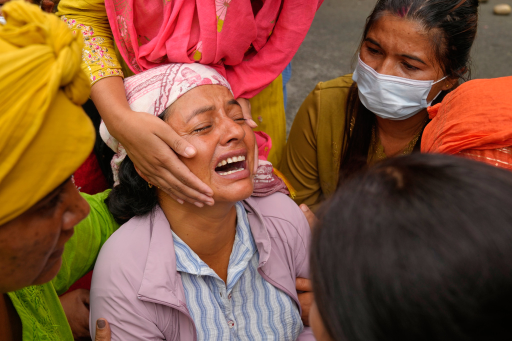 Relatives console Muna Khadka, center, who lost her son Aayush Khadka in flash floods, at a cremation ground in Chitwan, Nepal, Monday, Aug. 31, 2026. (AP Photo/Dar Yasin) CORRECTION: Corrects to clarify that this was at a separate cremation ground and not during a mass burial. Also corrects the second name of Aayush to Khadka instead of Khada.