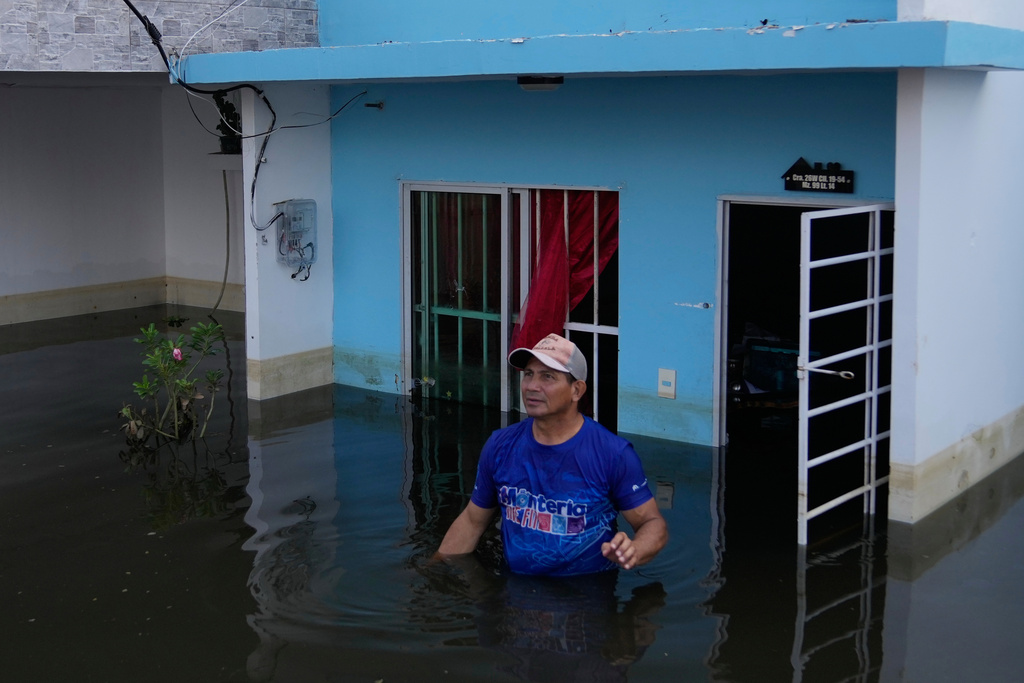 A man stands at his home after the Sinu River overflowed in Monteria, Colombia, Tuesday, Feb. 10, 2026. (AP Photo/Fernando Vergara)