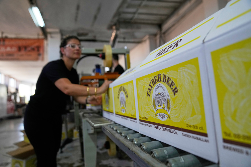 Nadin Khoury, 36, packs Taybeh beer products on a production line of the Family's Palestinian Taybeh Brewery Co. in the West Bank town of Taybeh, Saturday, Sept. 6, 2025. (AP Photo/Nasser Nasser)