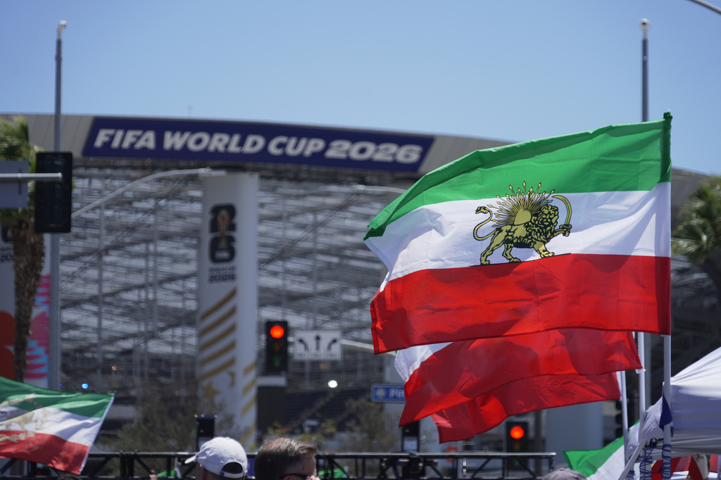 Pre-revolutionary Iranian flags stand during a protest outside Los Angeles Stadium before the World Cup Group G soccer match between Iran and New Zealand in Inglewood, Calif., near Los Angeles, Monday, June 15, 2026. (AP Photo/Ty ONeil)