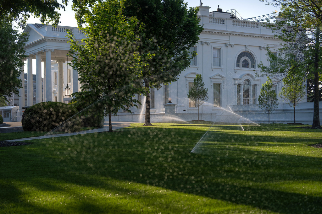 Sprinklers water the North Lawn of the White House, Thursday, April 23, 2026, in Washington. (AP Photo/Mark Schiefelbein)