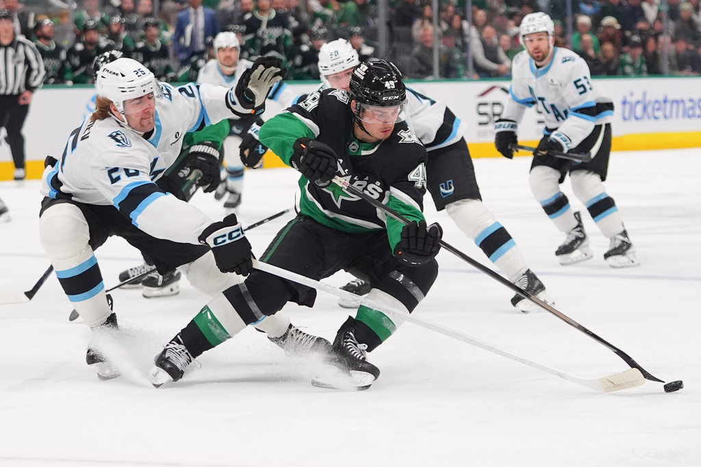 Dallas Stars center Justin Hryckowian (49) and Utah Mammoth defenseman Dmitri Simashev (26) skate for the puck during the first period of an NHL hockey game Friday, Nov. 28, 2025, in Dallas. (AP Photo/LM Otero)
