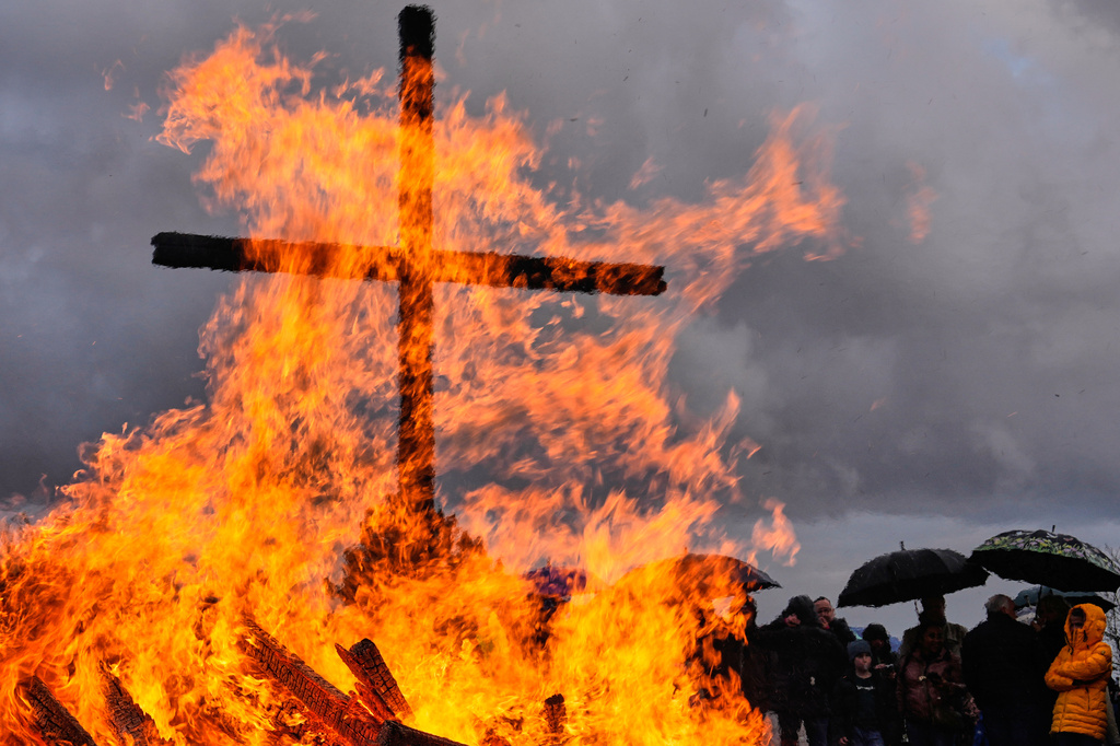 People attend a traditional Easter fire, a traditional bonfire lit symbolizing the resurrection of Jesus Christ, on a mine dump of the last German coal mine, in Bottrop, Germany, Sunday, April 5, 2026. (AP Photo/Martin Meissner)