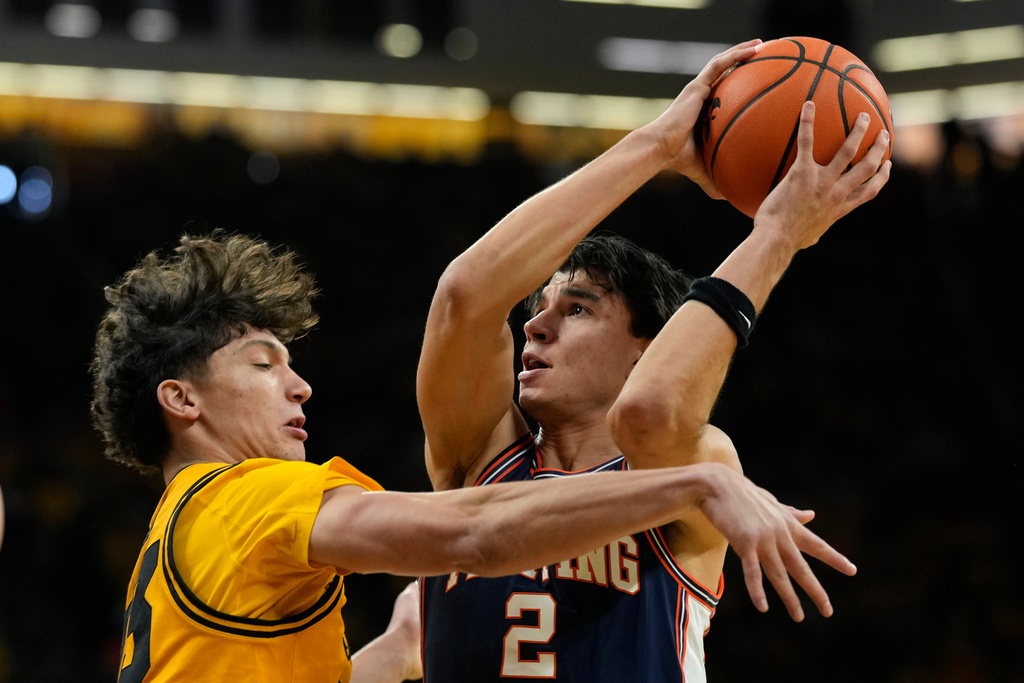 Illinois guard Andrej Stojakovic (2) shoots over Iowa guard Isaia Howard, left, during the first half of an NCAA college basketball game, Sunday, Jan. 11, 2026, in Iowa City, Iowa. (AP Photo/Charlie Neibergall)