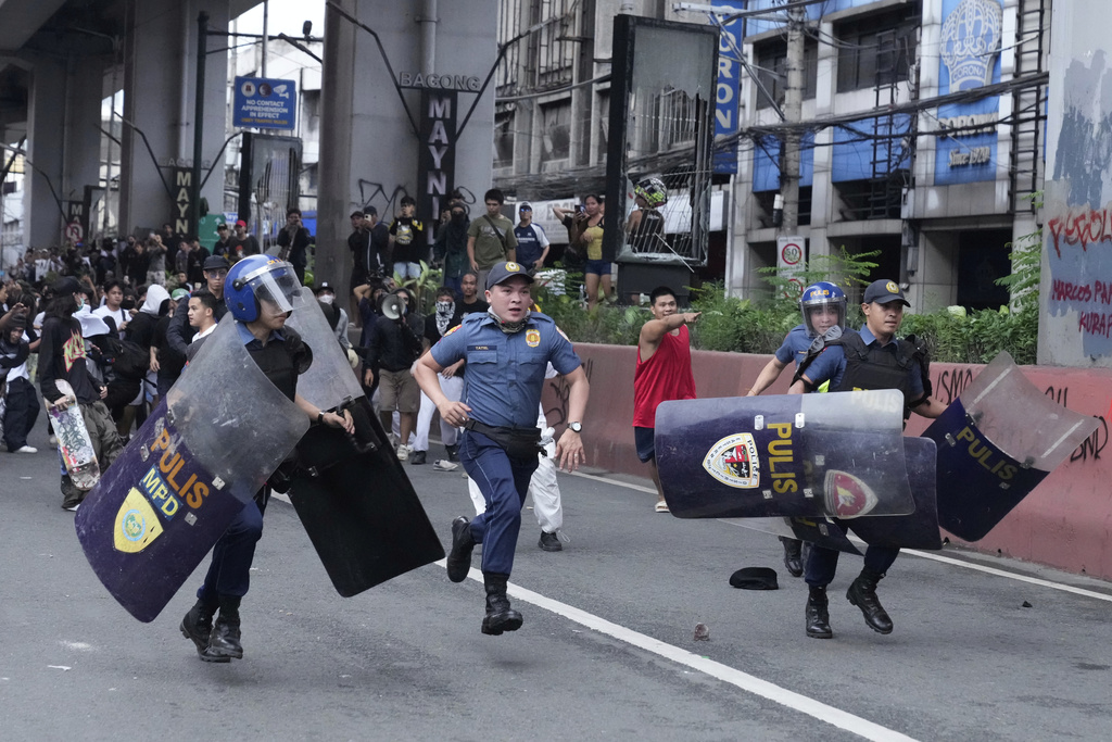 Police run as anti-corruption protesters chase them away during clashes in Manila, Philippines on Sunday, Sept. 21, 2025. (AP Photo/Aaron Favila)