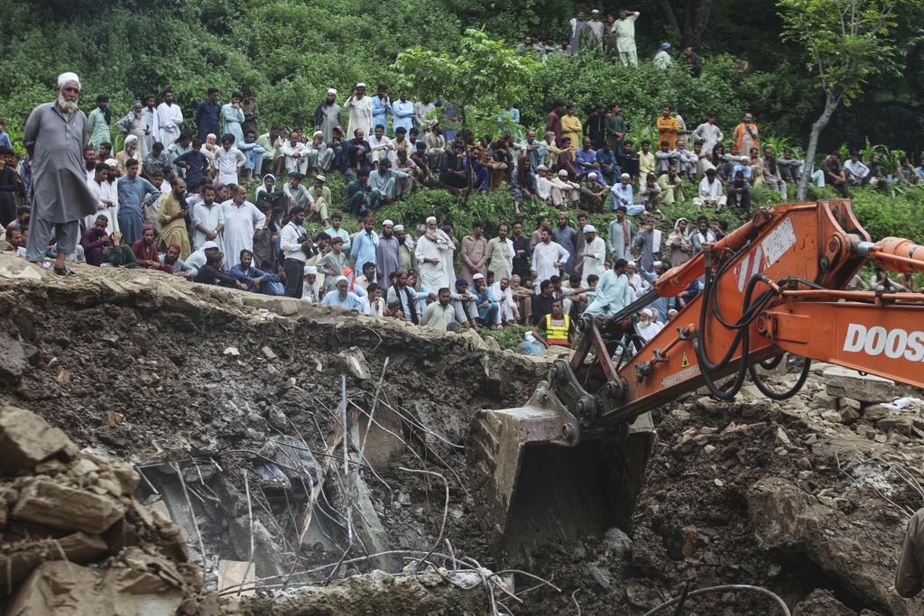Rescue workers use a excavator to search victims through the rubble of damaged homes following Monday's flash flooding due to heavy rains, in Dalori village in Swabi, a district of Pakistan's Khyber Pakhtunkhwa province, Tuesday, Aug. 19, 2025. (AP Photo/Muhammad Zubair)