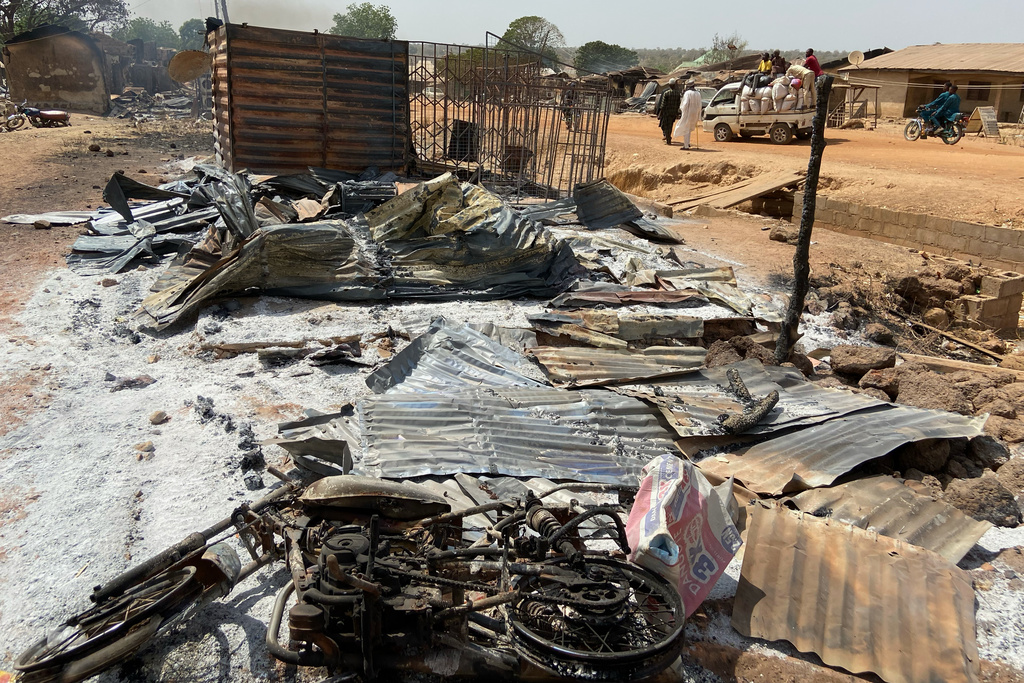 Charred objects lie on the ground where homes and a market once stood, days after an attack in the village of Woro, Nigeria, Thursday, Feb. 5, 2026. (AP Photo/Musa Salim)