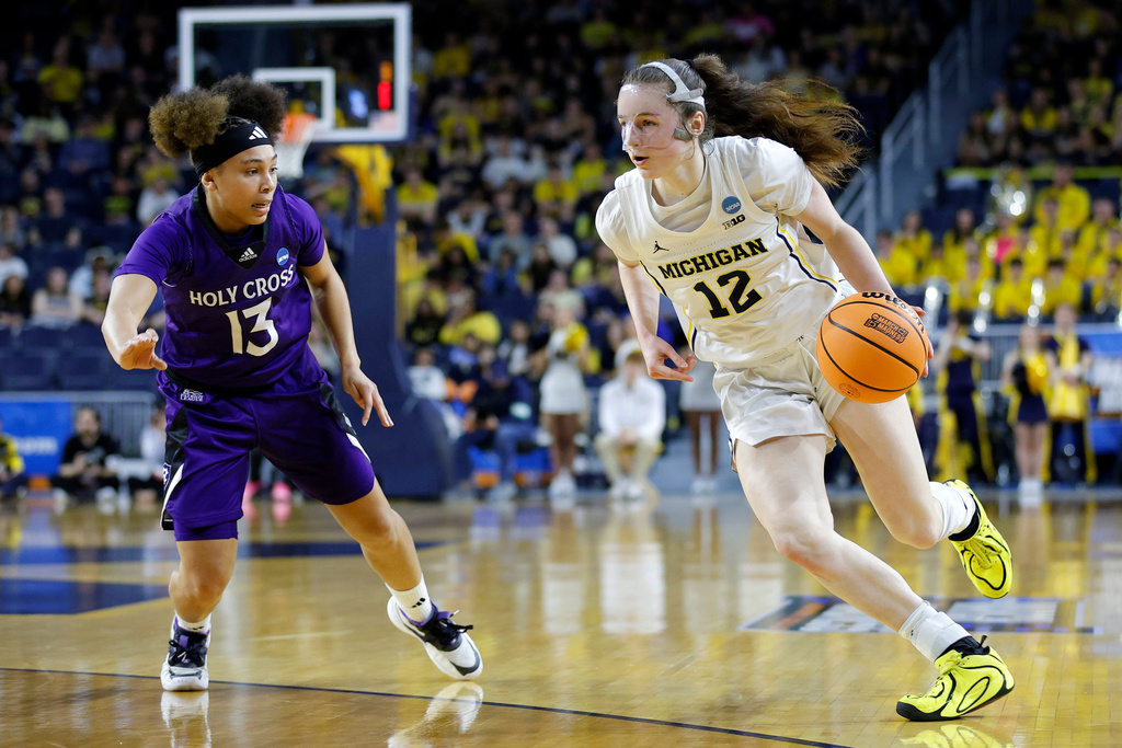 Michigan guard Syla Swords, right, drives against Holy Cross guard Asia Wilson (13) during the first half in the first round of the NCAA college basketball tournament, Friday, March 20, 2026, in Ann Arbor, Mich. (AP Photo/Al Goldis)
