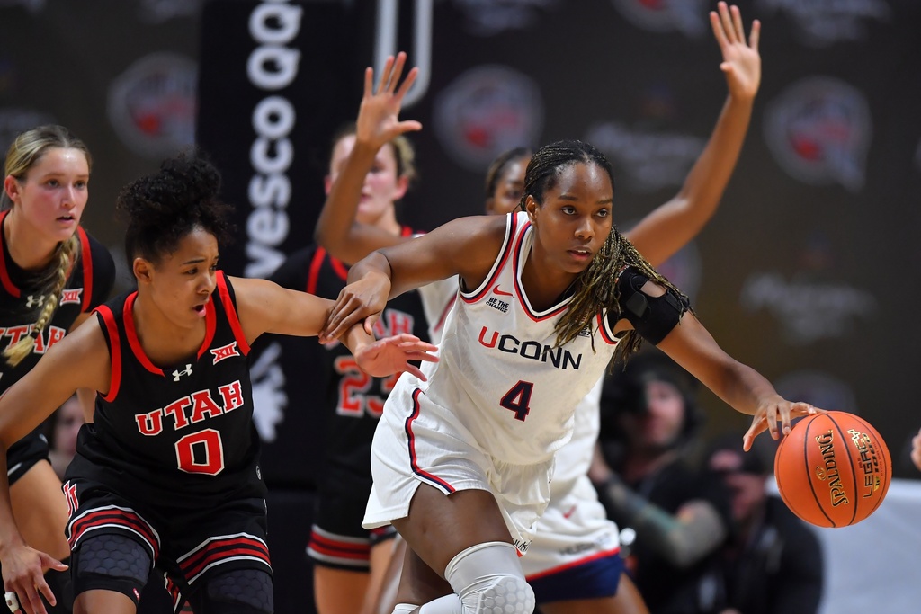 UConn guard Blanca Quinonez (4) drives with the ball as Utah guard Lani White (0) defends in the first half of an NCAA college basketball game, Sunday, Nov. 23, 2025, in Uncasville, Conn. (AP Photo/Steven Senne)