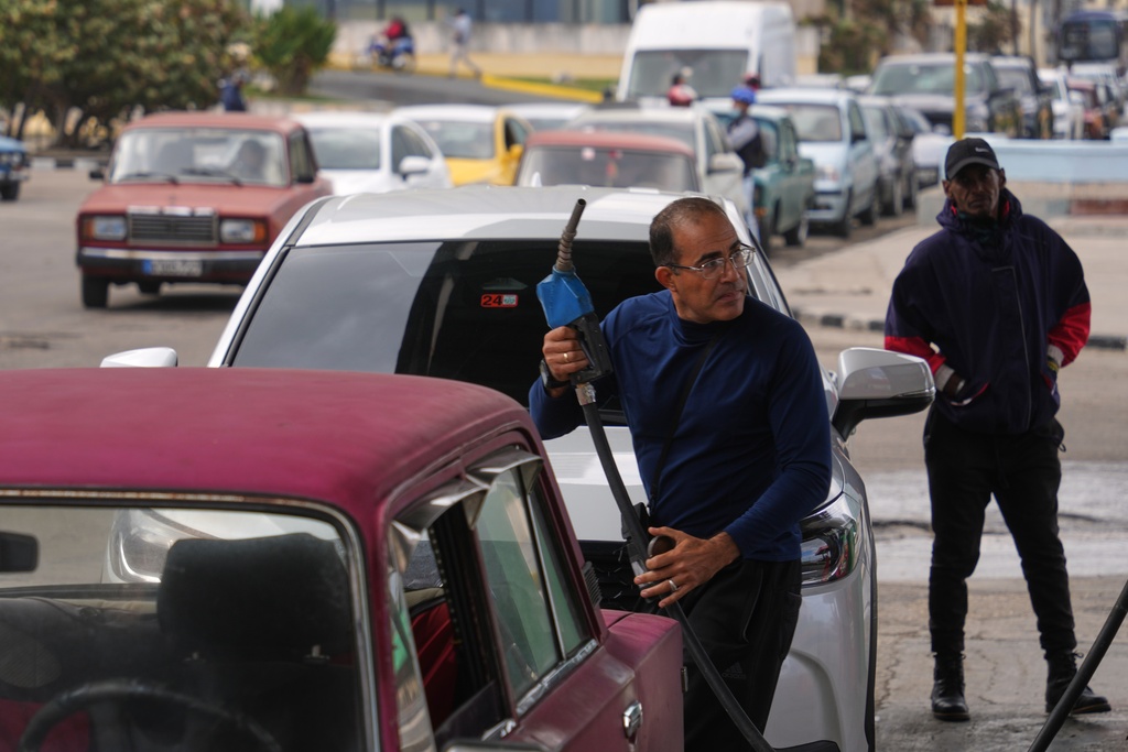 A driver refuels others wait in a long line behind to fill up at a gas station in Havana, Cuba, Tuesday, Jan. 27, 2026. (AP Photo/Ramon Espinosa)