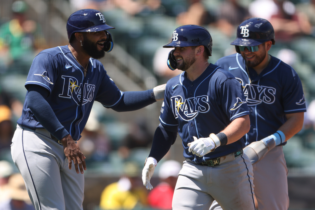 Tampa Bay Rays' Liam Hicks, middle, is congratulated by teammate Junior Caminero, left, after hitting a three-run home run during the fourth inning of a baseball game against the Athletics Wednesday, Aug. 12, 2026, in West Sacramento, Calif. (AP Photo/Scott Marshall)