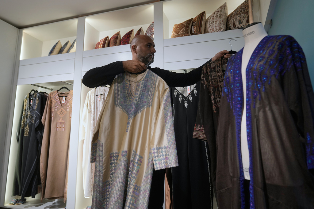 Ali Jaafar, the general manager of Inaash Association, arranges clothes at the embroidery workshop in Beirut, Tuesday, May 19, 2026. (AP Photo/Bilal Hussein)