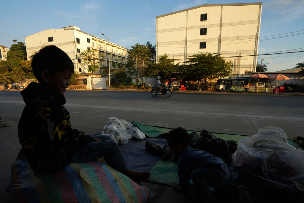 FILE - A boy plays near a building, where some people trafficked under false pretenses are being forced to work in online scams targeting people all over the world, in Phnom Penh, Cambodia, Feb. 9, 2025. (AP Photo/Heng Sinith, File)