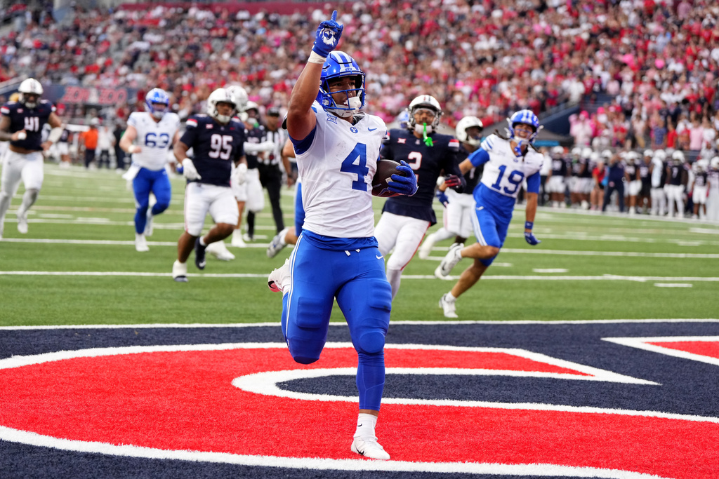 BYU running back LJ Martin (4) scores a touchdown against Arizona in the first half of an NCAA college football game Saturday, Oct. 11, 2025, in Tucson, Ariz. (AP Photo/Rick Scuteri)