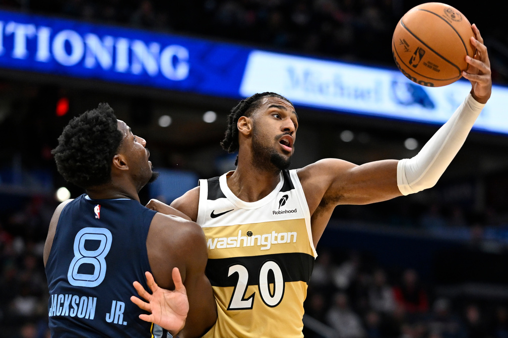 Washington Wizards center Alex Sarr (20) grabs a rebound against Memphis Grizzlies forward Jaren Jackson Jr. during the first half of an NBA basketball game, Sunday, Dec. 28, 2025, in Washington. (AP Photo/John McDonnell)