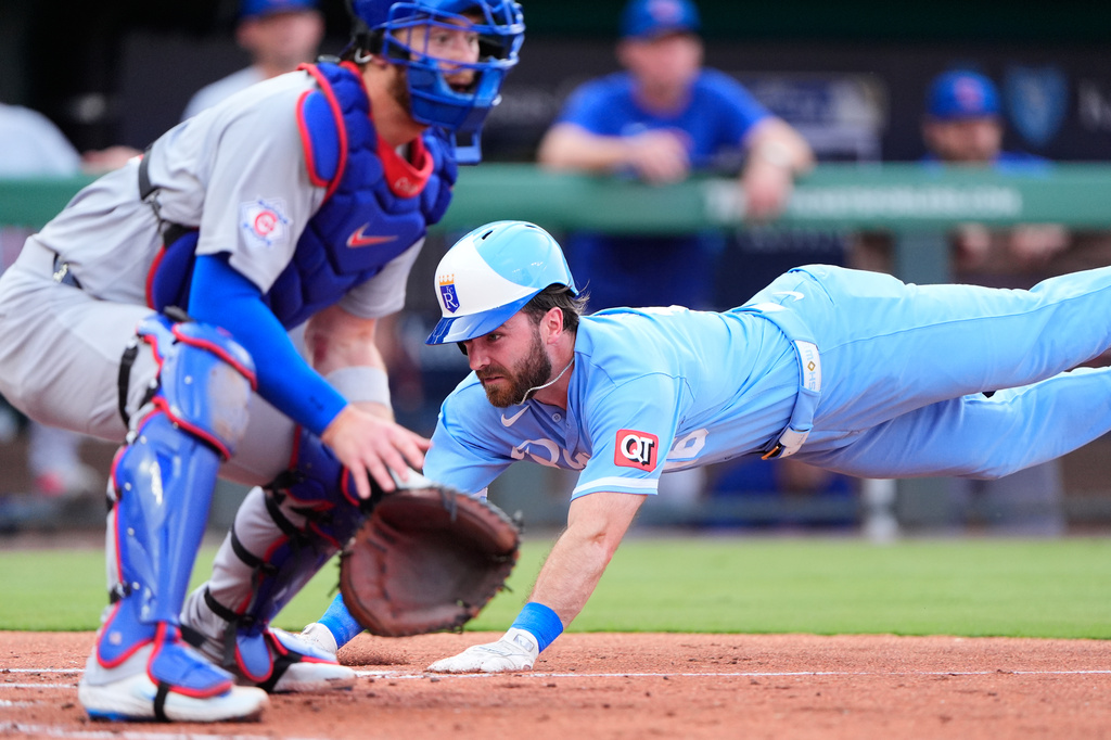 Kansas City Royals' John Rave dives home past Chicago Cubs catcher Carson Kelly to score on a two-run single by Josh Rojas during the second inning of a baseball game Saturday, Aug. 8, 2026, in Kansas City, Mo. (AP Photo/Charlie Riedel)
