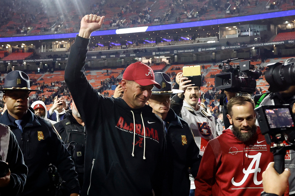 Alabama head coach Kalen Deboer, center, reacts after a win over Auburn in an NCAA college football game, Saturday, Nov. 29, 2025, in Auburn, Ala. (AP Photo/Butch Dill)