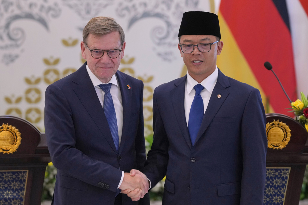 German Foreign Minister Johann Wadephul, left, shakes hands with his Indonesian counterpart Sugiono at the end of their joint press conference in Jakarta, Indonesia, Wednesday, Aug. 20, 2025. (AP Photo/Dita Alangkara)