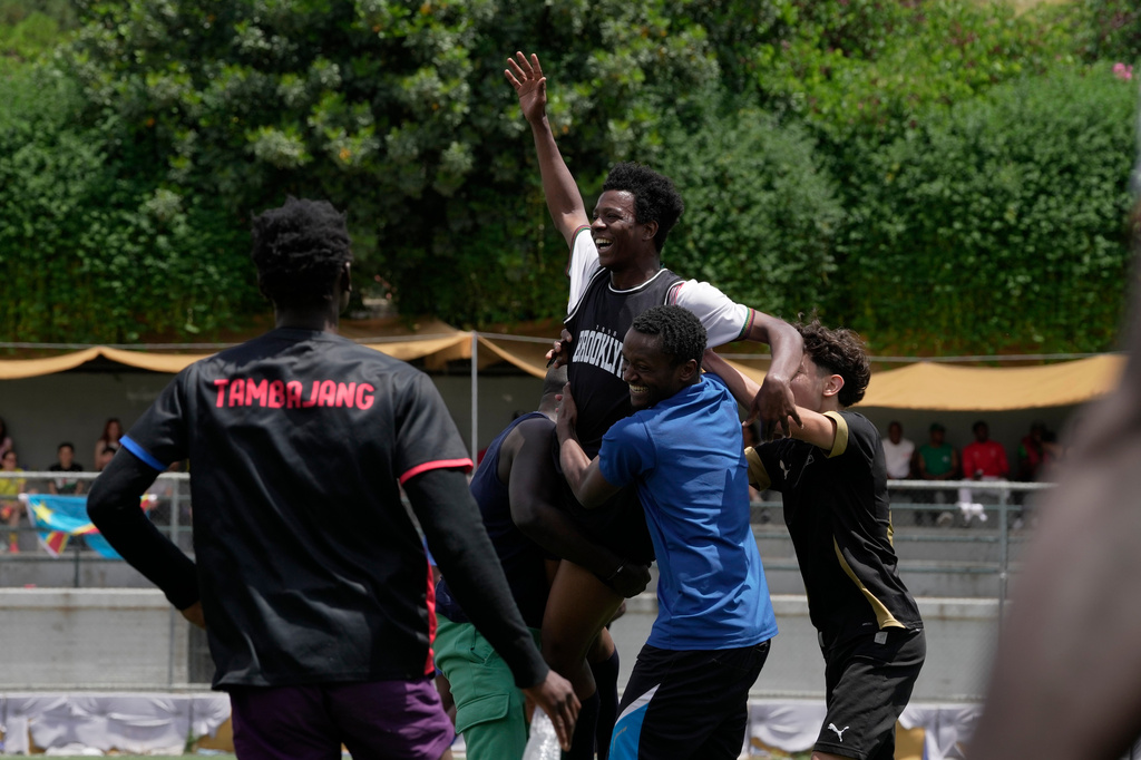 A migrant from Mali celebrates with teammates after scoring a goal during a semifinal soccer match against Congo for the Kypseli Mundial in Athens, Greece, on Sunday, May 24, 2026. (AP Photo/Thanassis Stavrakis)