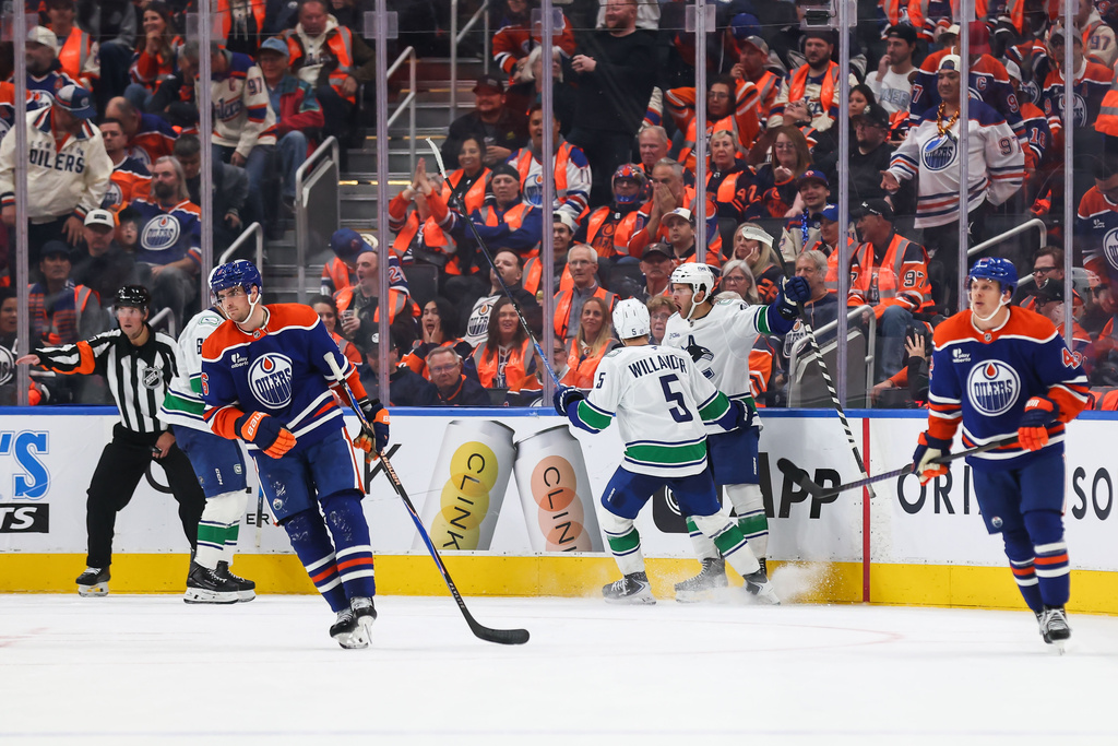 Vancouver Canucks' Tom Willander (5) and Paul Cotter (47) celebrate Cotter's game-winning goal against the Edmonton Oilers during overtime NHL hockey action in Edmonton on Tuesday, Sept. 29, 2026. (Codie McLachlan/The Canadian Press via AP)