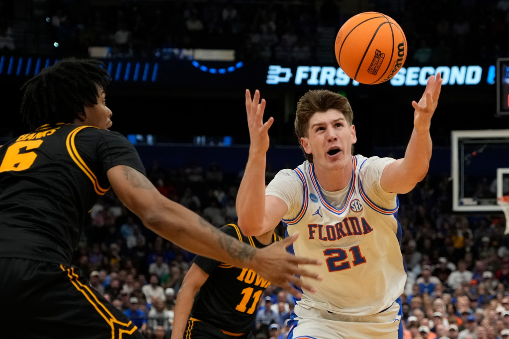 Florida forward Alex Condon (21) goes after a loose ball next to Iowa guard Tavion Banks (6) during the first half in the second round of the NCAA college basketball tournament, Sunday, March 22, 2026, in Tampa, Fla. (AP Photo/John Raoux)