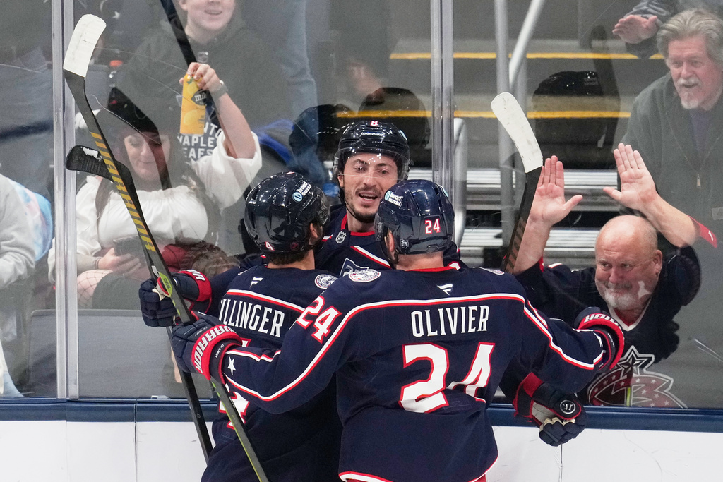 Columbus Blue Jackets defenseman Zach Werenski, center, celebrates his goal with teammates Cole Sillinger, left, and Mathieu Olivier (24) in the first period of an NHL hockey game against the Toronto Maple Leafs in Columbus, Wednesday, Oct. 29, 2025. (AP Photo/Sue Ogrocki)