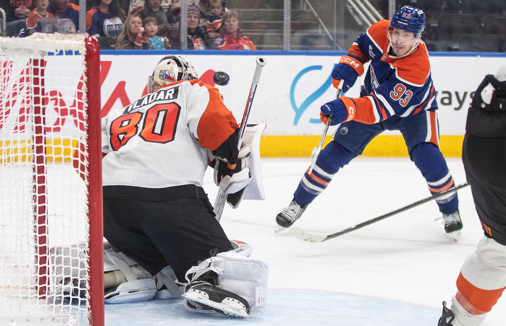 Philadelphia Flyers' goalie Dan Vladar (80) makes a save on Edmonton Oilers' Ryan Nugent-Hopkins (93) during second period NHL action, in Edmonton on Saturday, Jan. 3, 2026. (Jason Franson/The Canadian Press via AP)