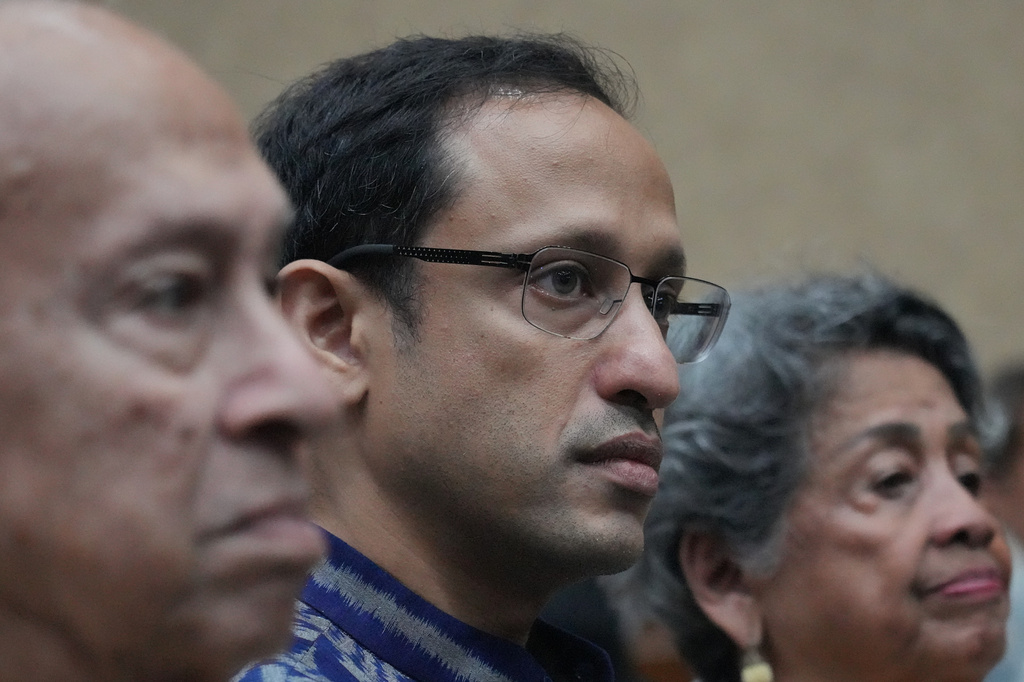 Nadiem Anwar Makarim, center, former Education Minister and the co-founder of Indonesia's payments platform and ride-hailing and payments company Gojek, who is accused of corruption in a government project to procure school laptops, is flanked by his parents Nono Anwar Makarim, left, and Atika Algadrie before the start of his trial hearing at the Corruption Court in Jakarta, Indonesia, Monday, April 20, 2026. (AP Photo/Achmad Ibrahim)