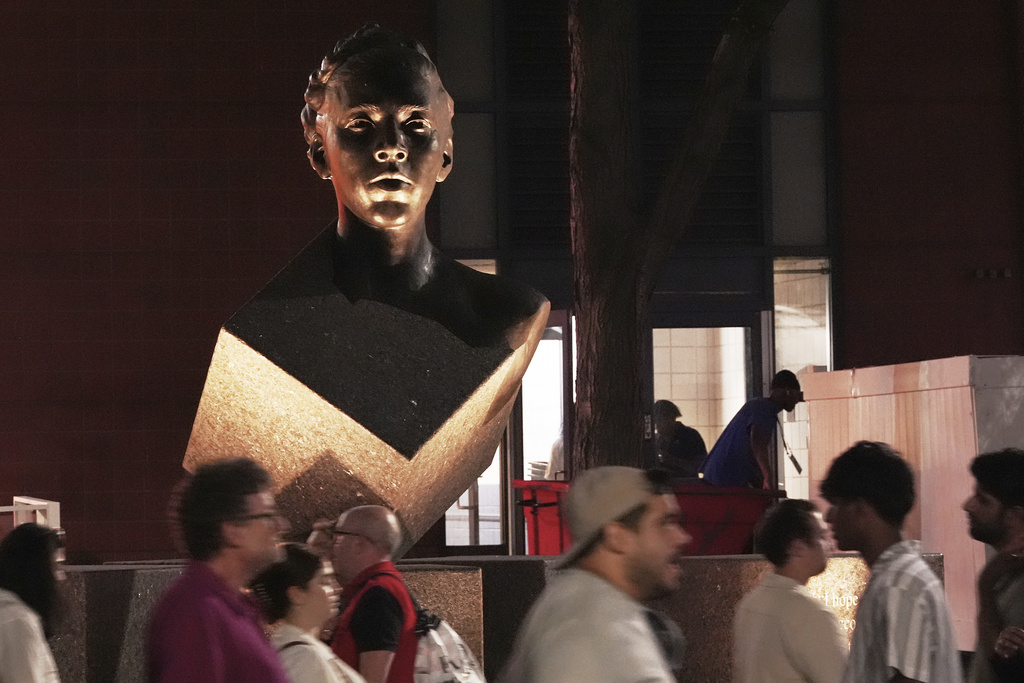 People walk in front of the Althea Gibson statue outside of Arthur Ashe Stadium during the first-round of the U.S. Open tennis championships, Sunday, Aug. 24, 2025, in New York. (AP Photo/Frank Franklin II)