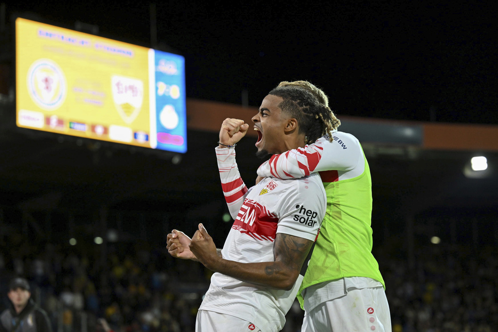 Stuttgart's Lorenz Assignon, left, celebrates after converting his kick during a penalty shootout against Eintracht Braunschweig during a DFB Pokal, German Cup, soccer match, Tuesday, Aug. 26, 2205, in Brunswick, Germany. (Swen Pförtner/dpa via AP)