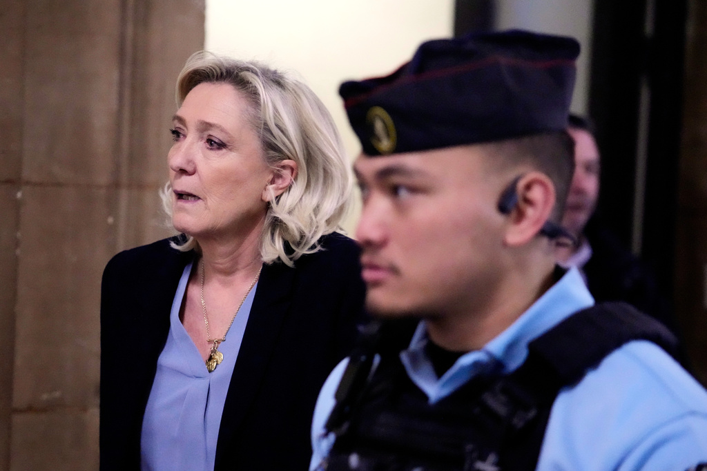 Far-right leader Marine Le Pen, left, walks outside the courtroom during a short break in her appeals trial in Paris, Tuesday, Jan. 20, 2026. (AP Photo/Michel Euler)