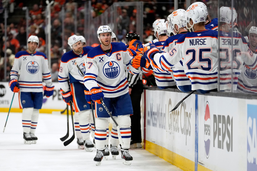 Edmonton Oilers center Connor McDavid, center, is congratulated by teammates after scoring during the third period of Game 3 in the first round of the NHL hockey Stanley Cup playoffs series against the Anaheim Ducks, Friday, April 24, 2026, in Anaheim, Calif. (AP Photo/Mark J. Terrill)