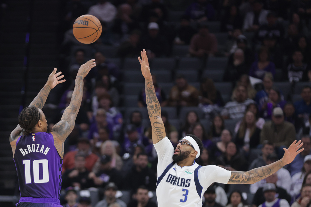 Sacramento Kings guard Demar Derozan (10) shoots a 3-point shot over Dallas Mavericks forward Anthony Davis (3) during the first half of an NBA basketball game Tuesday, Jan. 6, 2026, in Sacramento, Calif. (AP Photo/Scott Marshall)