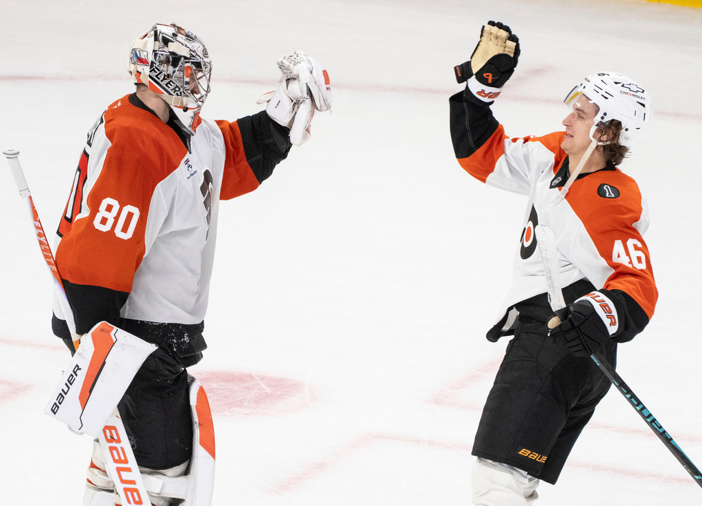 Philadelphia Flyers goaltender Dan Vladar (80) is congratulated by teammate Trevor Zegras (46) following their shootout NHL hockey win over the Montreal Canadiens in Montreal on Tuesday, Nov. 4, 2025. (Christinne Muschi/The Canadian Press via AP)