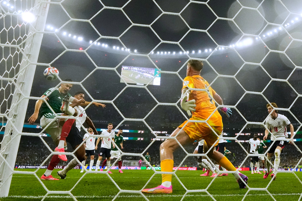 Mexico's Cesar Montes, left, and England's Jude Bellingham (10) battle for the ball in front of England goalkeeper Jordan Pickford (1) during the World Cup round of 16 soccer match between Mexico and England in Mexico City, Sunday, July 5, 2026. (AP Photo/Ricardo Mazalan )