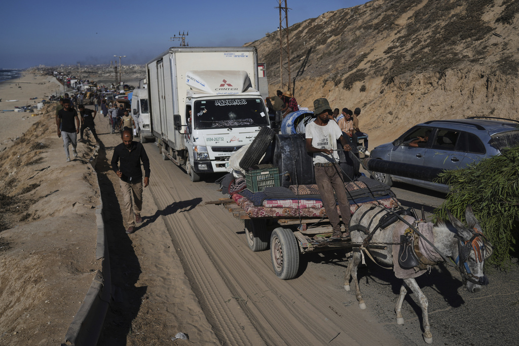 Displaced Palestinians fleeing northern Gaza carry their belongings along the coastal road toward southern Gaza, Wednesday, Sept. 10, 2025, after the Israeli army issued evacuation orders from Gaza City. (AP Photo/Abdel Kareem Hana)