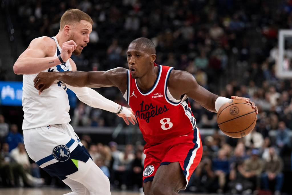 Los Angeles Clippers guard Kris Dunn, right, drives to the basket as Minnesota Timberwolves guard Donte DiVincenzo, left, defends during the first half of an NBA basketball game Thursday, Feb. 26, 2026, in Inglewood, Calif. (AP Photo/Kyusung Gong)