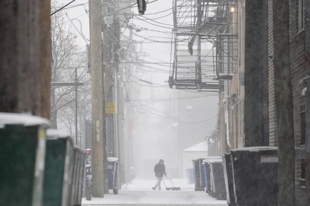 A person shovels snow in a Chicago alley Saturday, Nov. 29, 2025. (AP Photo/Kiichiro Sato)