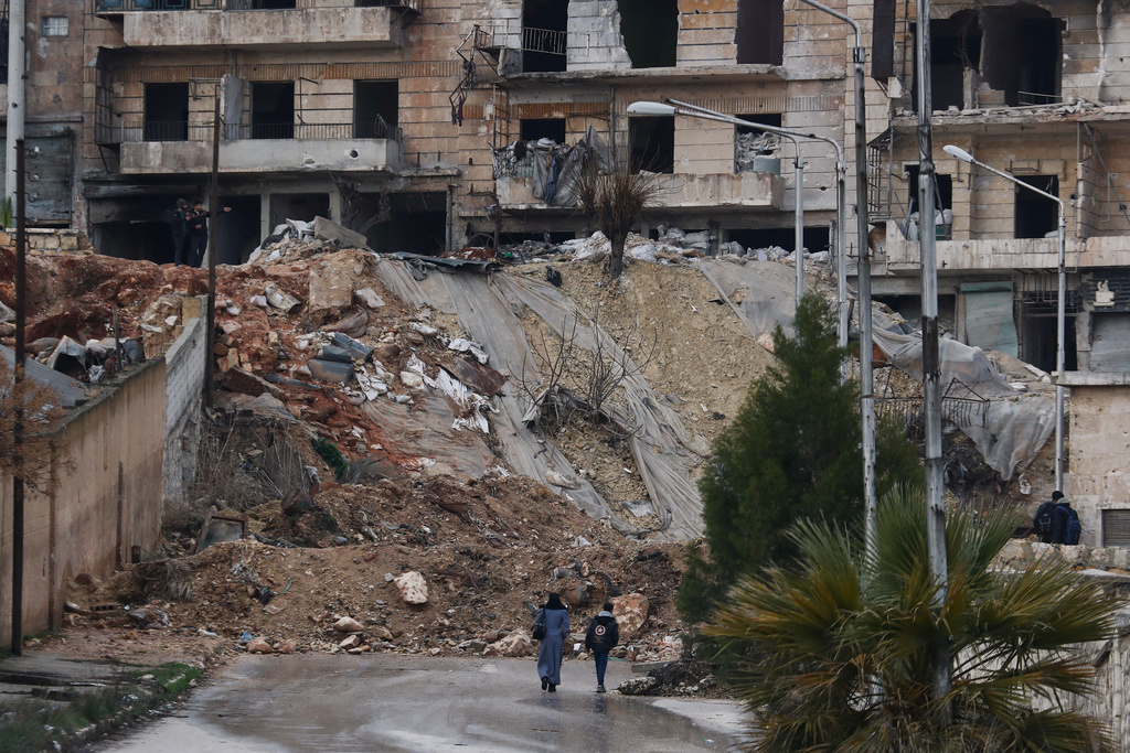 People walk along a street in the Kurdish-majority neighborhood of Sheikh Maqsoud, in Aleppo, Syria, Saturday, Feb. 14, 2026. (AP Photo/Omar Sanadiki)