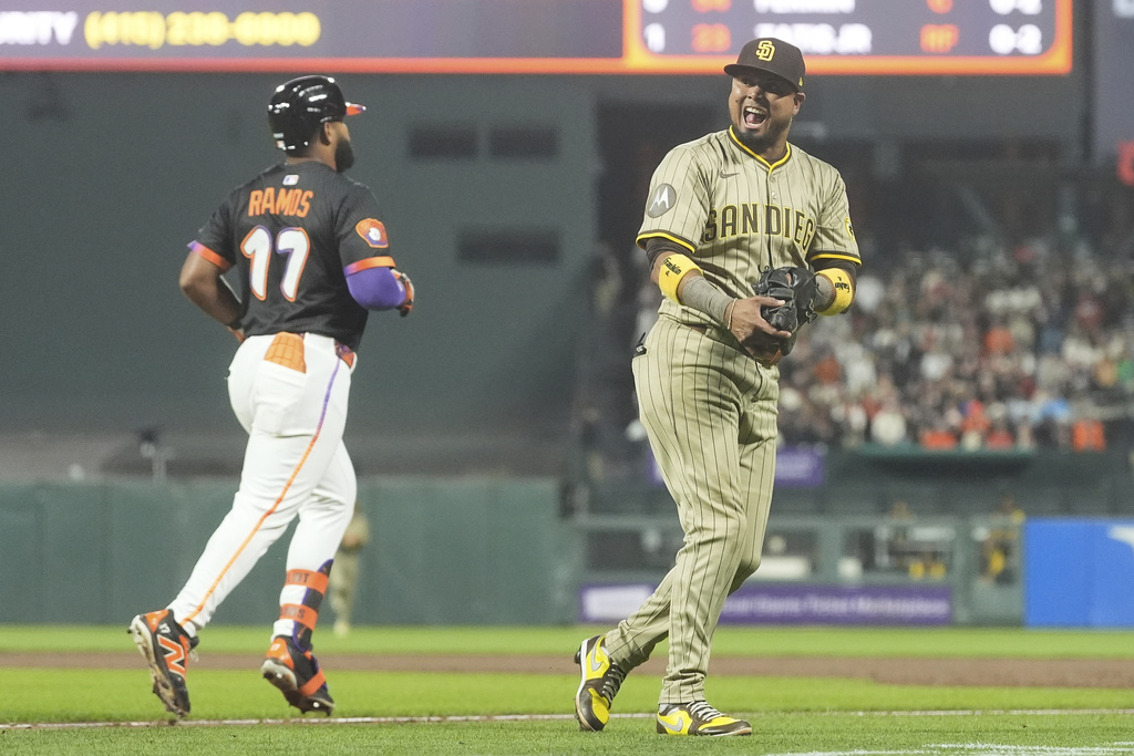 San Diego Padres first baseman Luis Arraez, right, reacts after catching a pop out hit by San Francisco Giants' Heliot Ramos (17) during the sixth inning of a baseball game in San Francisco, Tuesday, Aug. 12, 2025. (AP Photo/Jeff Chiu)