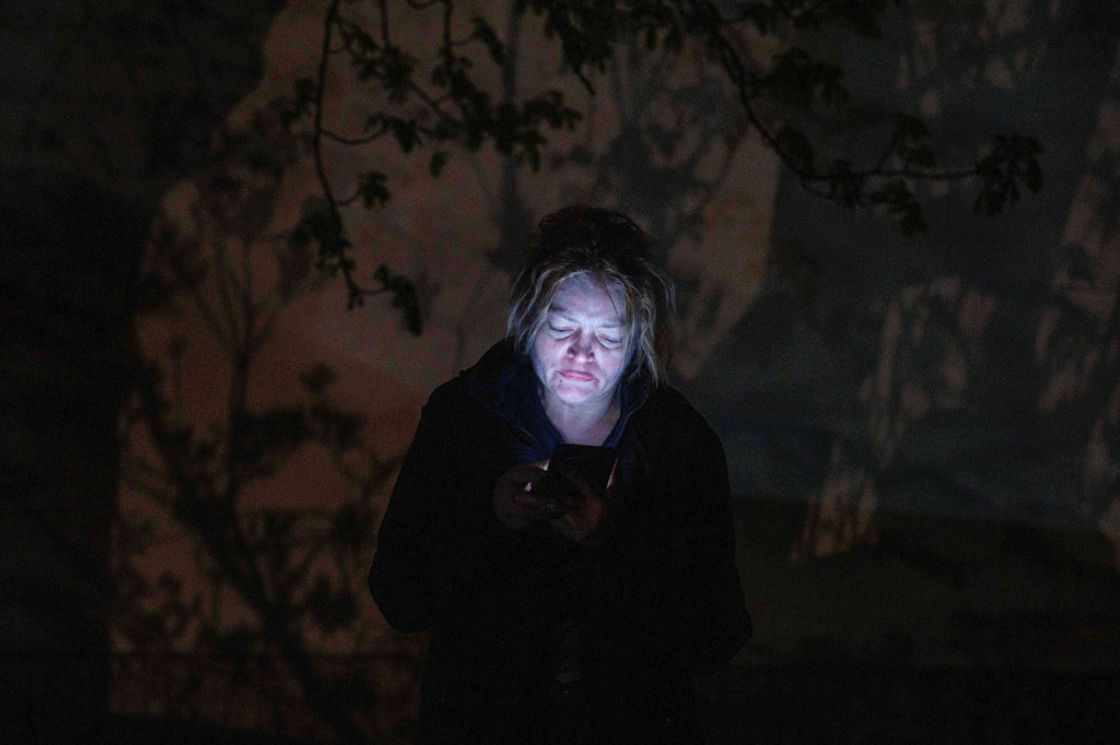 A woman speaks via a phone in front of her house damaged after a Russian strike on residential area in Kyiv, Ukraine, on Thursday, April 16, 2026. (AP Photo/Evgeniy Maloletka)