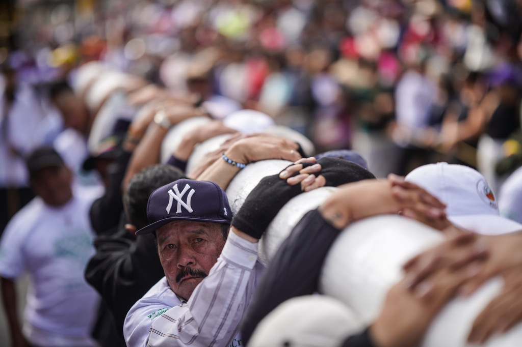 Faithful carry a cross to the Tree of Life during a Good Friday procession in the Ciudad Bolivar neighborhood of Bogota, Colombia, Friday, April 3, 2026. (AP Photo/Ivan Valencia)