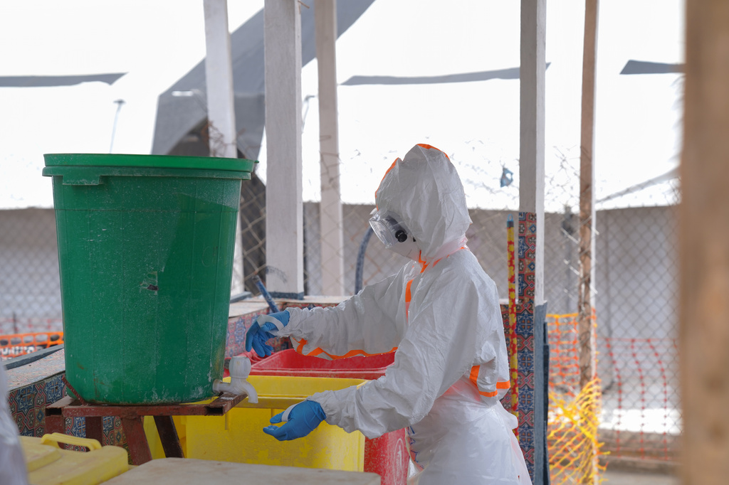 A health worker in protective gear washes her hands at the treatment centre in Bunia General Hospital in Ituri, eastern Congo, Tuesday, Aug. 11, 2026. (AP Photo/Dieudonne Dirole)