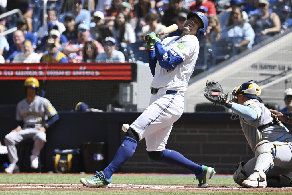 Toronto Blue Jays designated hitter George Springer (4) reacts after getting hit by a pitch from Milwaukee Brewers starting pitcher Brandon Woodruff during the first inning of a baseball game in Toronto on Sunday, Aug. 31, 2025. (Jon Blacker/The Canadian Press via AP)