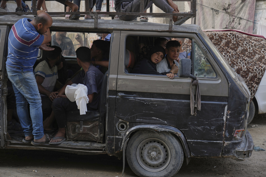 Palestinians carry the body of Mohammed Al-Sukni, who was killed while trying to reach aid trucks, as his mother sits at the front of the vehicle before his funeral in Gaza City, Thursday, Aug. 21, 2025. (AP Photo/Jehad Alshrafi)